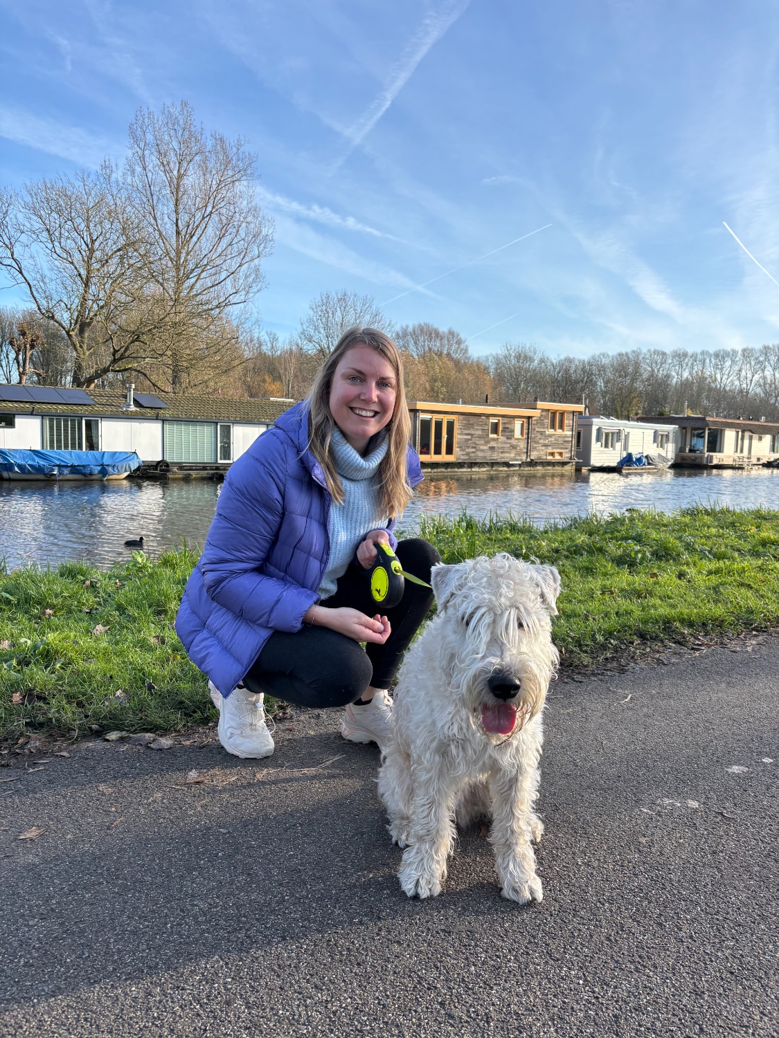 Kelly buiten met een witte hond aan de waterkant