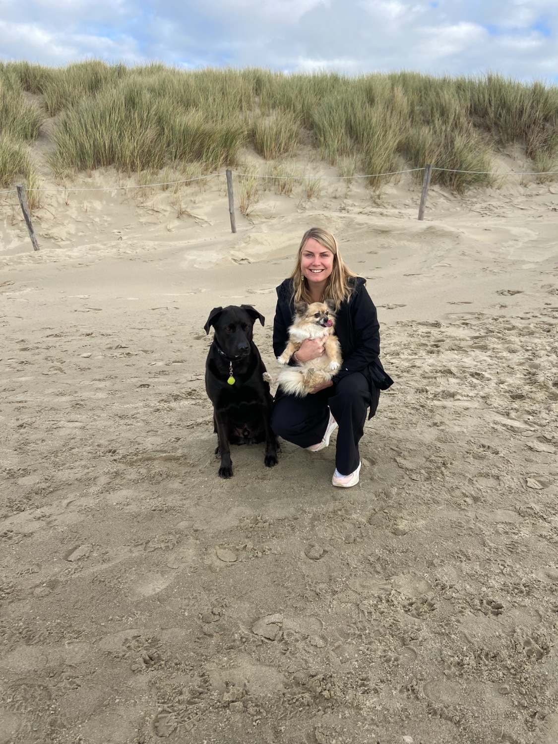 Kelly op het strand met een zwarte hond en een kleine hond